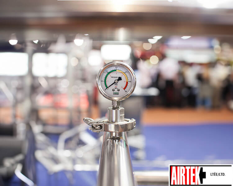 Close-up of a precision pressure gauge on Airtek industrial equipment, highlighting durability and accuracy in a manufacturing environment.