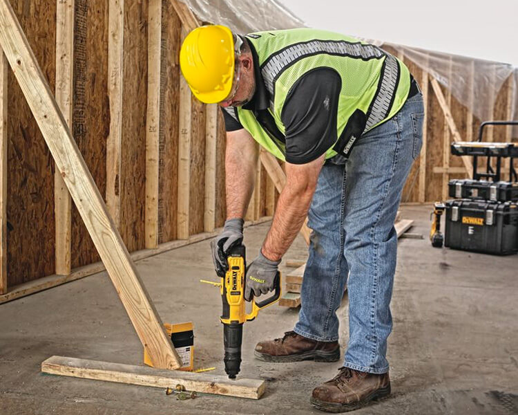 A construction worker wearing a high-visibility jacket and helmet holds a slow sign near a roadwork site. the logo of pioneer is visible in the corner.