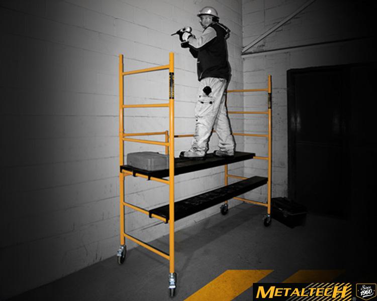 A Metaltech worker on a ladder, adjusting a metal scaffold, demonstrating safety and skill in a building project.