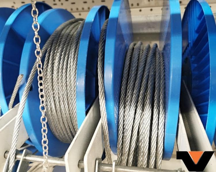 2 blue reels of wound steel cables on a shelf