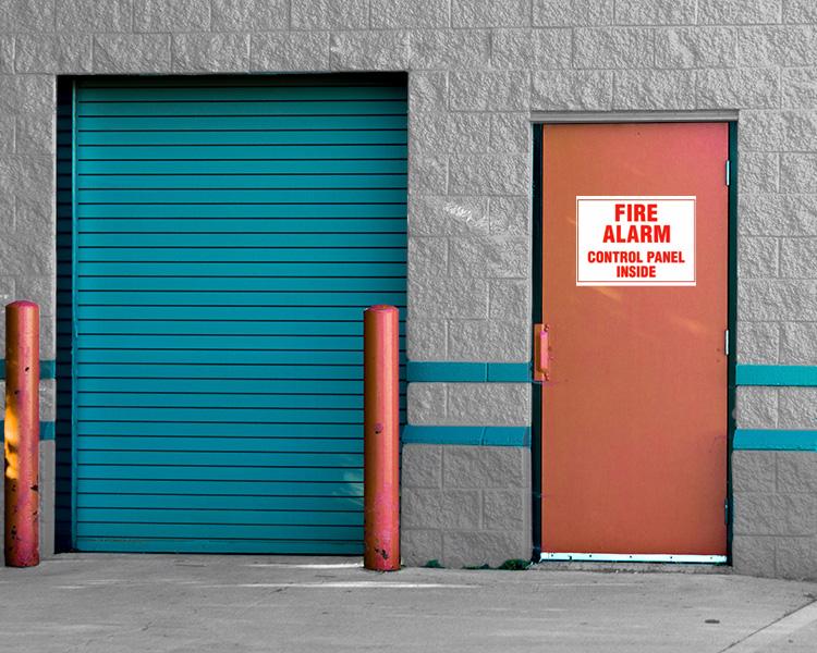 A door displaying a fire alarm sign, crucial for fire safety and emergency preparedness.